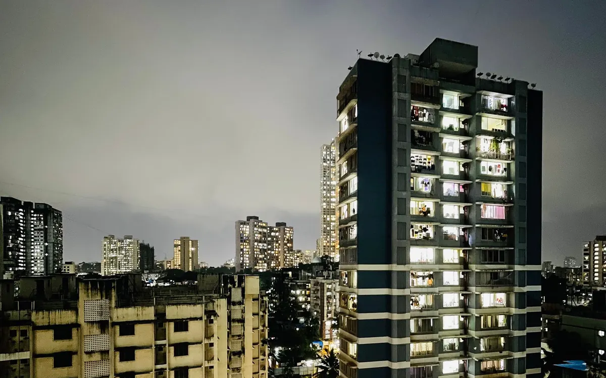 Residential apartment towers lit up at night in an Indian city