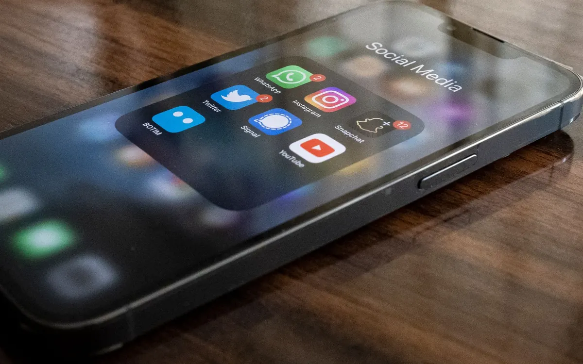 Smartphone with a folder of social media and messaging apps on its home screen